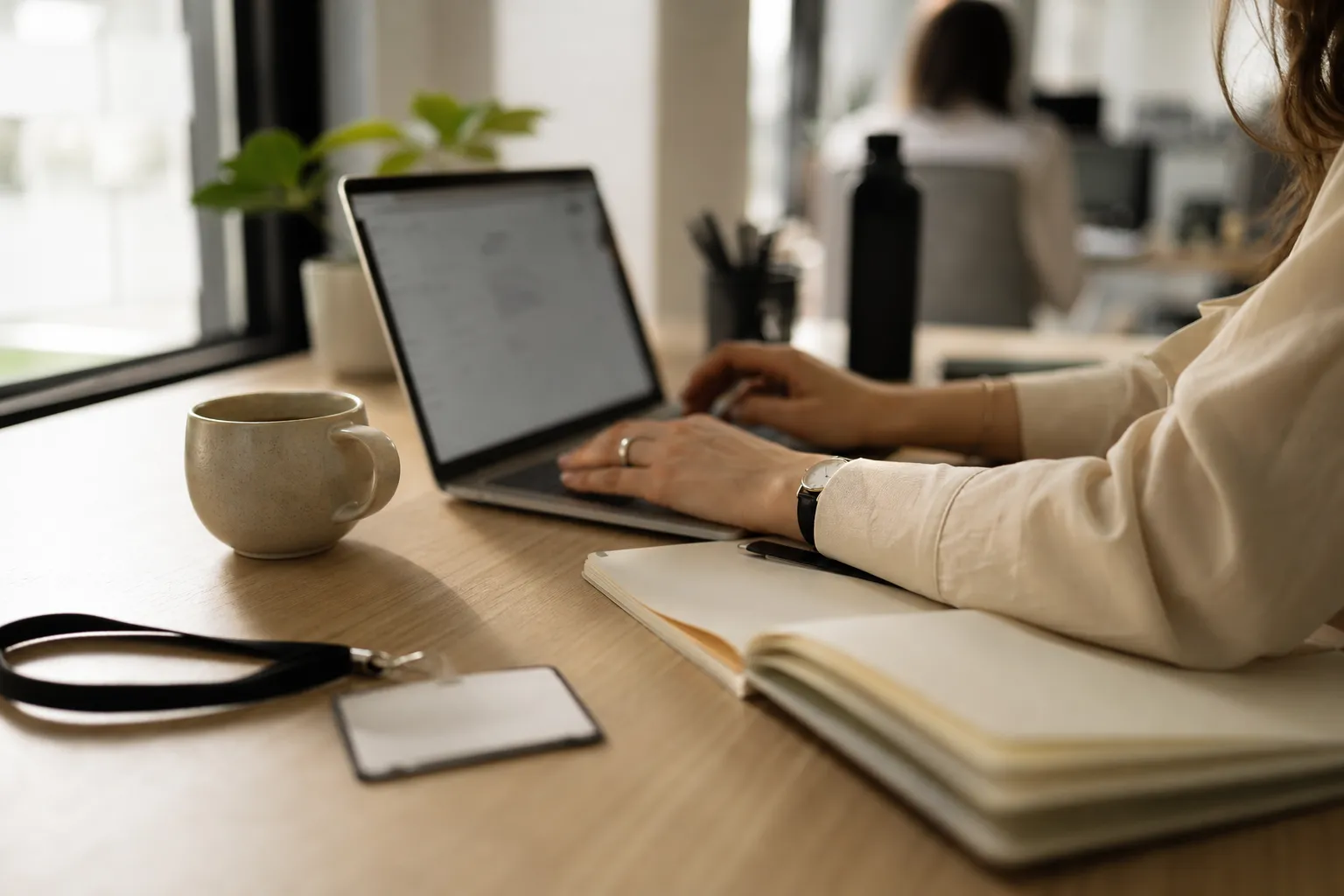 Mains d’une consultante sur le clavier d’un ordinateur portable, dans un bureau partagé